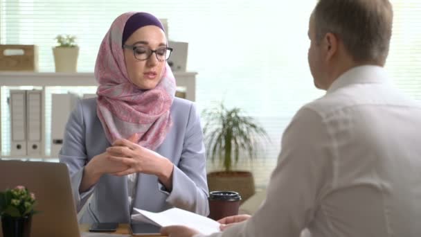 Young muslim business woman shake hands with a caucasian man during a meeting in office - Video, Çekim