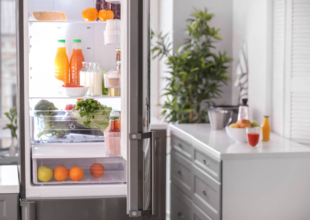 Открытый холодильник со свежими продуктами на кухне
 - Фото, изображение