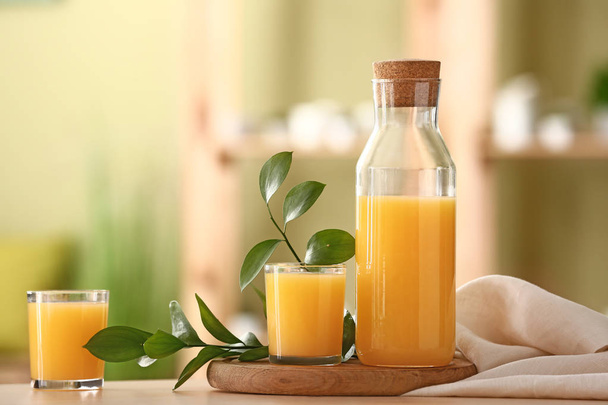 Masa üzerinde lezzetli portakal suyu şişe ve gözlük - Fotoğraf, Görsel