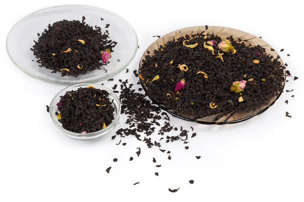 Tea leaves with chinese rose buds on saucers and beside - Photo, Image