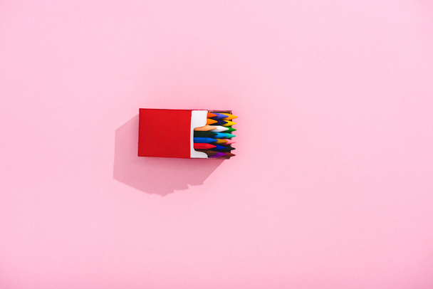 vista dall'alto di pastelli colorati in pacchetto di sigarette su rosa con spazio copia, concetto di fumo
 - Foto, immagini