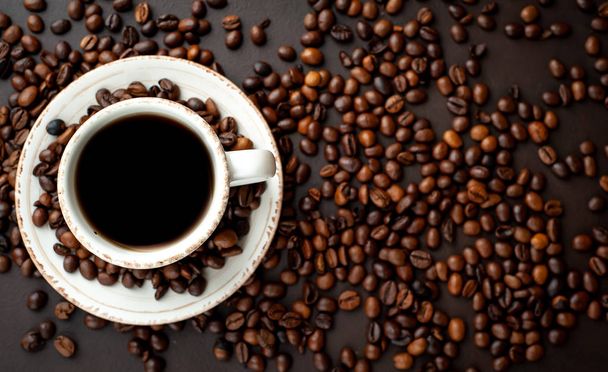 Taza de café fresco sobre fondo de piedra negra con granos de café
  - Foto, Imagen