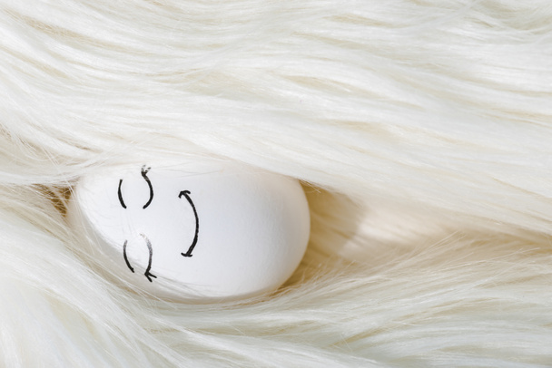 top view of egg with happy face expression in white wig - Fotó, kép