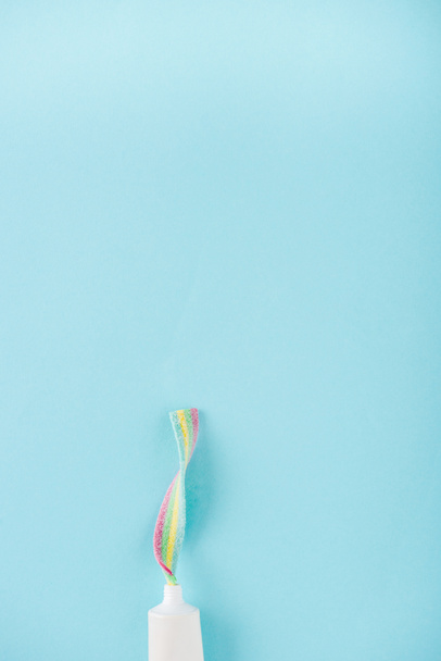 вид сверху на тюбик из зубной пасты с жевательными конфетками, изолированными на голубом с местом для копирования
 - Фото, изображение
