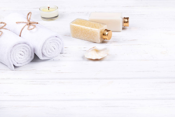 Spa, beauty and wellness products: cream, sea salt, towels, decorated with sea shell and candle with copy space.   - Photo, Image