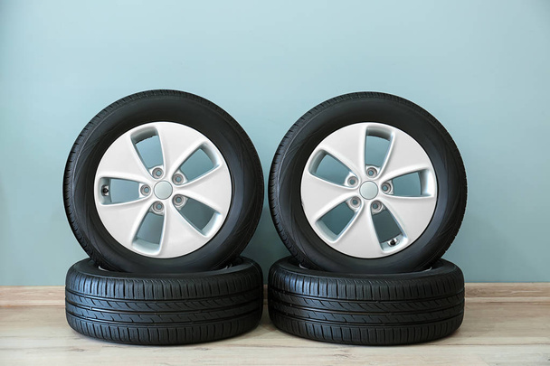 Neumáticos de coche cerca de pared color
 - Foto, Imagen