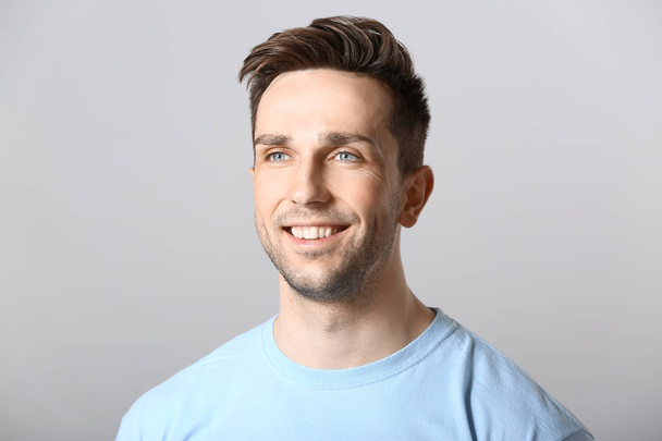Portrait of handsome man on grey background - Photo, Image