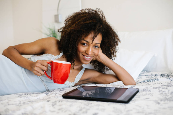Woman at home reading on digital tablet - Foto, imagen