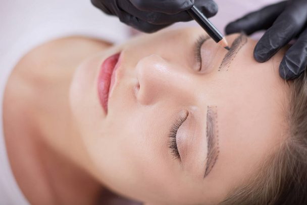 Cosmetologist aplicando a composição permanente nas sobrancelhas - Foto, Imagem