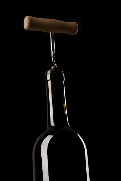 Wine bottle with corkscrew mounted - Foto, Bild