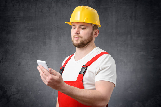 Construction worker using smartphone - Φωτογραφία, εικόνα