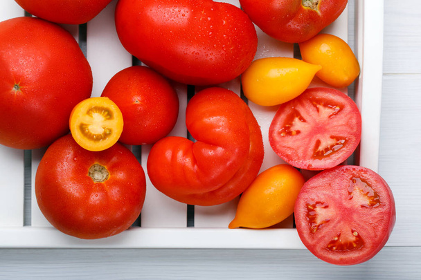 Different varieties of tomatoes on a white tray. Colorful red an - Photo, Image