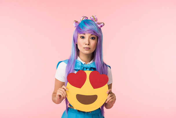 Anime κορίτσι σε μωβ περούκα κρατώντας πάθος συναισθηματική απομονώνεται σε ροζ - Φωτογραφία, εικόνα