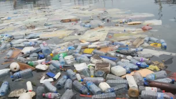 Pollution de l'environnement. Bouteilles en plastique, sacs, ordures dans la rivière, lac. Poubelles et pollution flottant dans l'eau - Séquence, vidéo