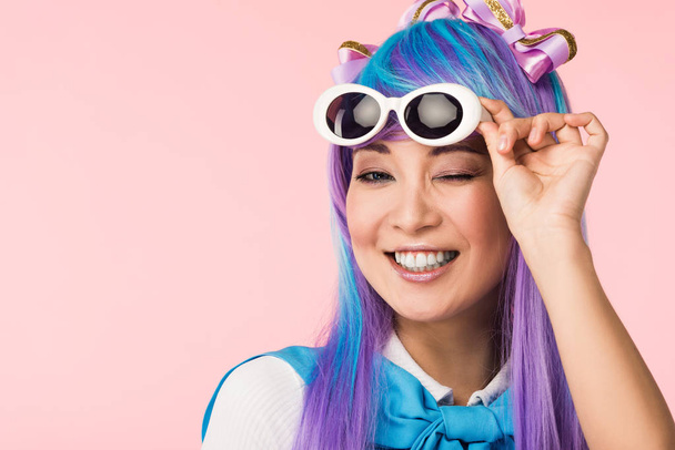 Chica de anime sonriente en peluca y gafas de sol aisladas en rosa
 - Foto, Imagen