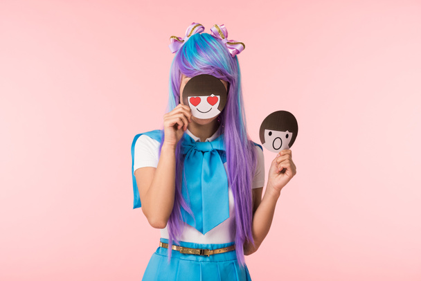 Chica anime en peluca púrpura sosteniendo emoticonos aislados en rosa
 - Foto, imagen