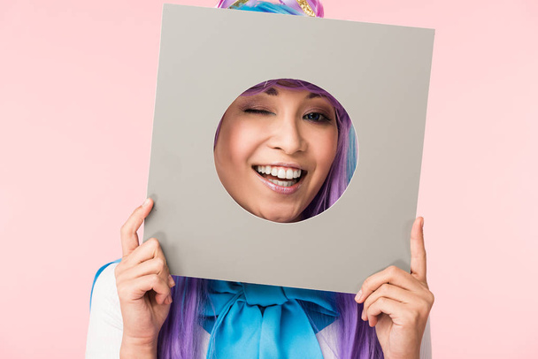 ピンクに孤立した段ボールを持つ笑顔のアジアのアニメの女の子 - 写真・画像