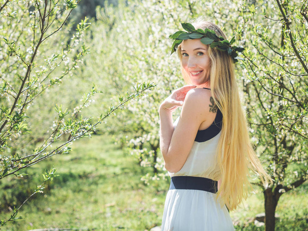 Young beautiful smiling woman in spring blossom trees. - Photo, Image