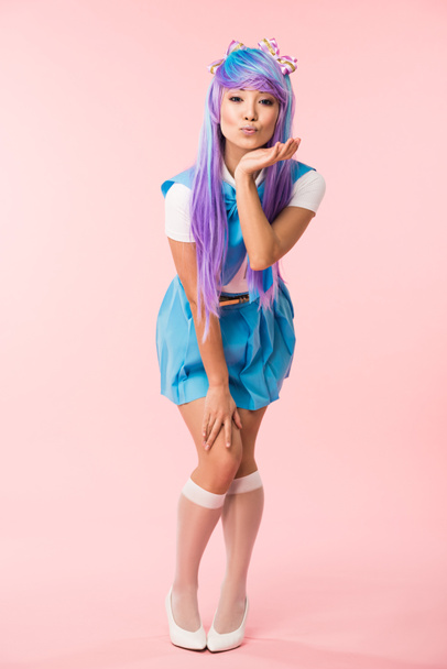 Full length view of asian anime girl in purple wig posing with kissing face expression on pink - Φωτογραφία, εικόνα