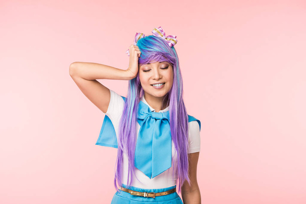 Smiling anime girl in purple wig with closed eyes on pink - Fotografie, Obrázek