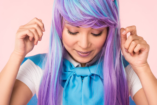 Смольничащая аниме девушка в парике, глядящая вниз, на розовом фоне
 - Фото, изображение