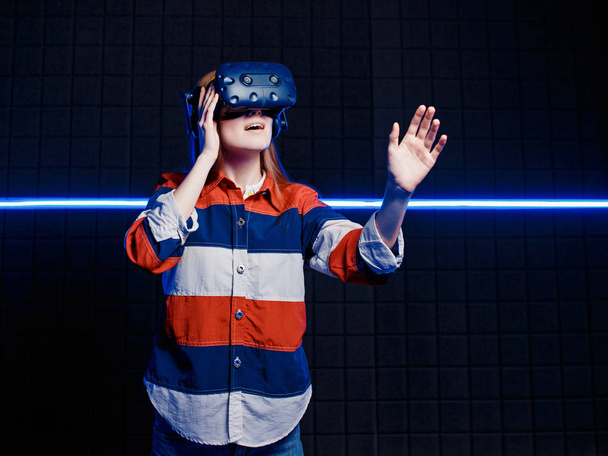 Young girl in a virtual reality helmet in the game room - Фото, зображення