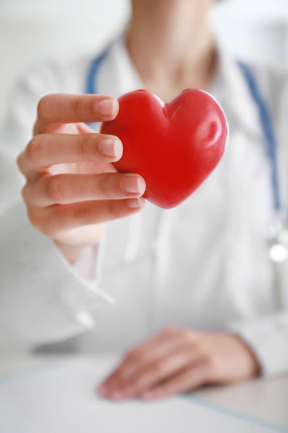 Cardiologist with red heart in clinic, closeup - Photo, Image