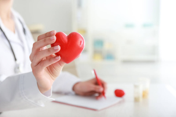 Cardiologista com coração vermelho na clínica, close-up - Foto, Imagem