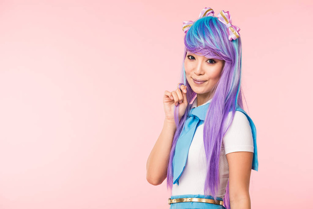 hermosa asiático anime chica en morado peluca mirando cámara aislado en rosa
 - Foto, imagen