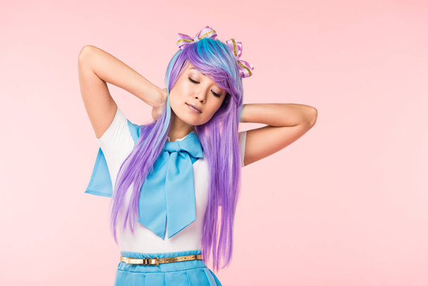 Anime girl in wig posing with closed eyes isolated on pink - Zdjęcie, obraz