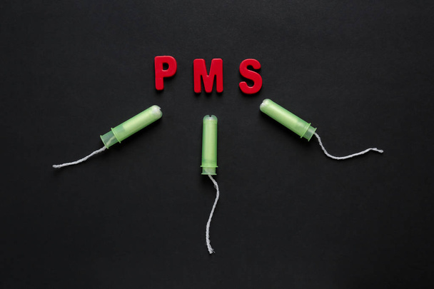Tampons and text PMS on dark background - Photo, Image