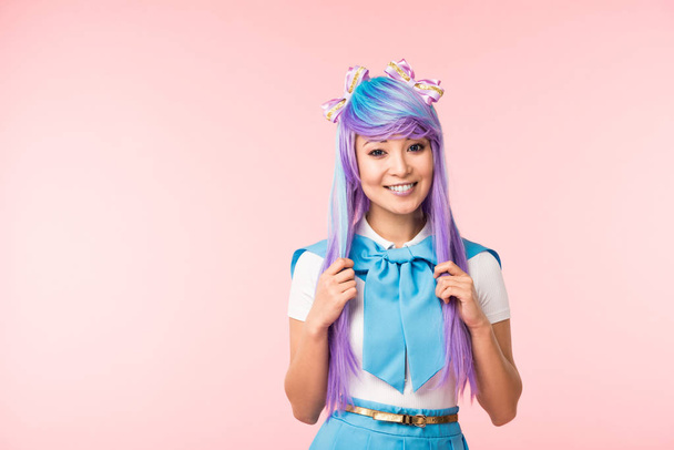 riéndose asiático anime chica tocando cabello aislado en rosa
 - Foto, Imagen