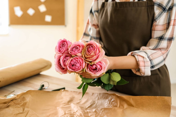 Флорист делает красивый букет за столом
 - Фото, изображение