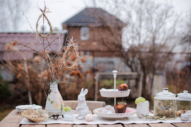 Served festive decorative table garden outdoors. Farm. Rustic style. Willow spring bloom. Flowers cookies glass jar. Easter - Photo, Image
