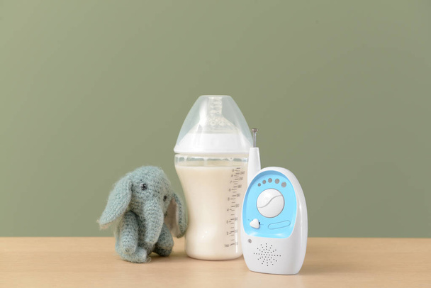 Moderno baby monitor con giocattolo e bottiglia di latte sul tavolo sullo sfondo a colori
 - Foto, immagini