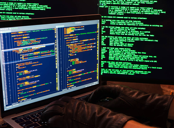 Hacking of database with admin access. Side view of hacker hands in gloves typing malicious code. Password theft hacking firewall concept - Photo, Image