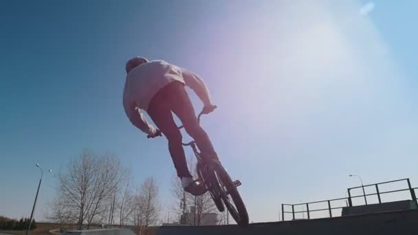 Um homem de bicicleta a fazer truques no parque de skate. Corrida e segurando um equilíbrio em uma roda dianteira
 - Filmagem, Vídeo