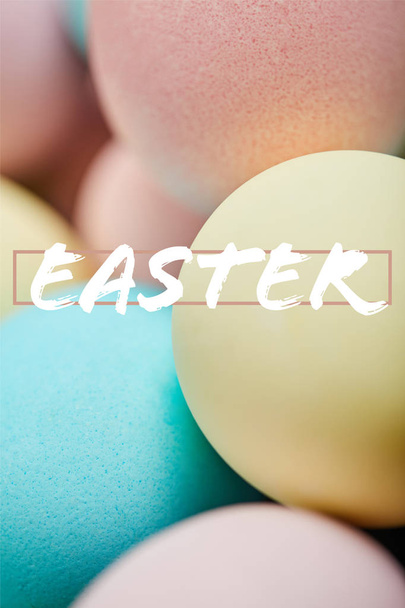 close up of pile of multicolored painted chicken eggs with Easter lettering  - Φωτογραφία, εικόνα