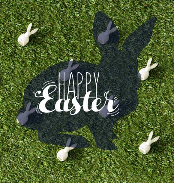 top view of decorative bunnies on green grass with happy Easter lettering  - Fotografie, Obrázek