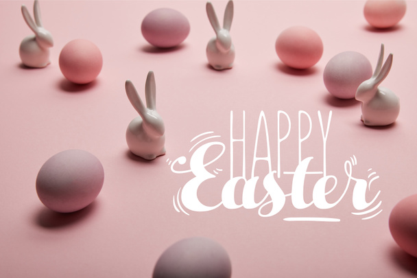 pink painted chicken eggs with decorative rabbits and happy Easter lettering  - Fotó, kép