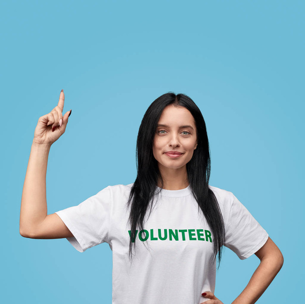 Confident volunteer pointing up - Foto, imagen