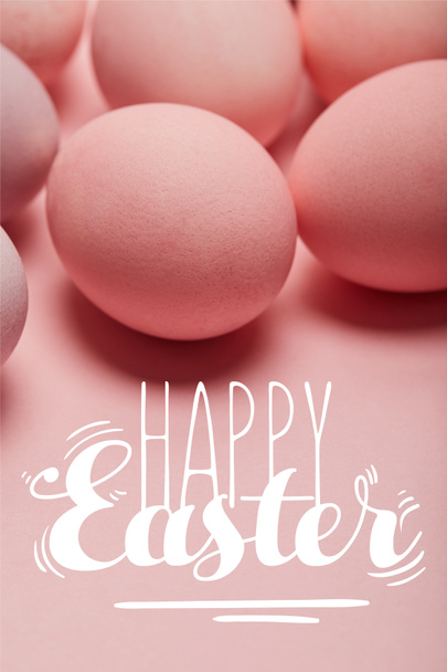 huevos de color rosa pintados en la superficie de color rosa con letras de Pascua feliz
 - Foto, imagen