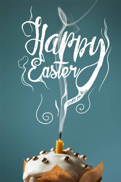selective focus of traditional Easter cake with fireless candle and smoke on blue background with happy easter lettering - Фото, зображення