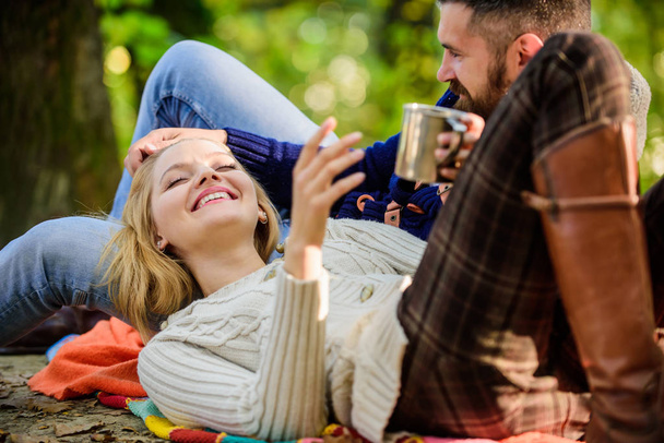 Cheerful couple. couple in love relax in autumn forest with tea or coffee. camping and hiking. happy woman and bearded man drink mulled wine. love date and romance. Family picnic. Valentines day - 写真・画像