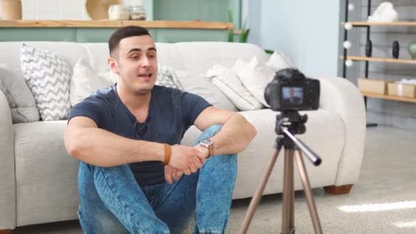 Jovem blogueiro do sexo masculino falando sobre câmera digital gravação de vídeo vlog em casa
 - Filmagem, Vídeo