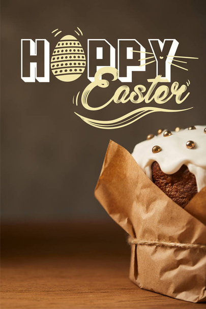 close up of traditional Easter cake with sprinkles in craft paper with happy easter lettering - Foto, Imagen