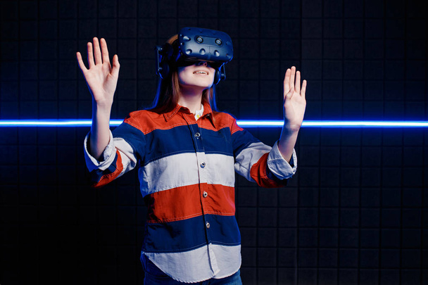 Young girl in a virtual reality helmet in the game room - Fotó, kép
