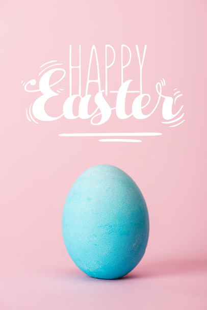 blauwe kip ei op roze achtergrond met Happy Easter belettering - Foto, afbeelding