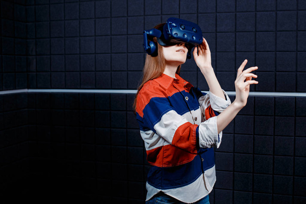 Молода дівчина в шоломі віртуальної реальності в ігровій кімнаті
 - Фото, зображення