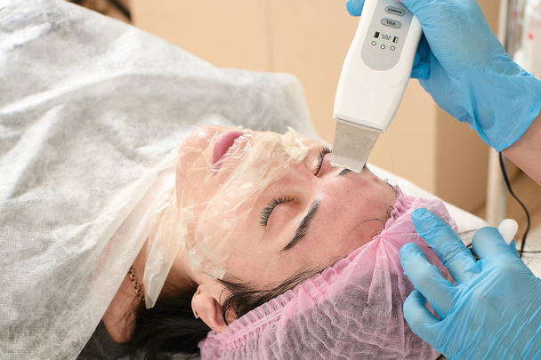 Giovane donna in salone di bellezza facendo ultrasuoni peeling e pulizia del viso procedura. - Foto, immagini